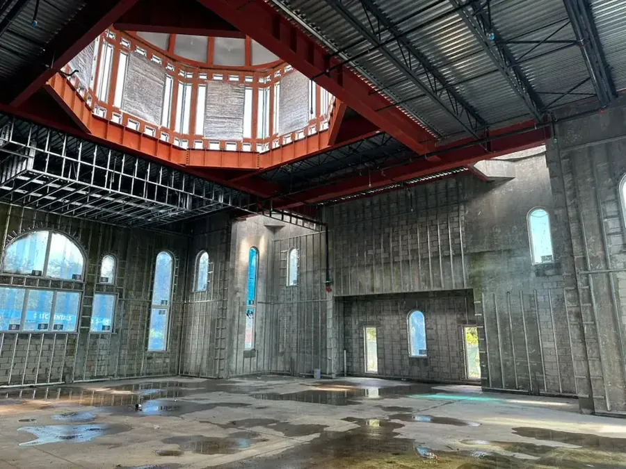 The octagonal dome seen from below, its orange steel frame open to the boarded drum above the ceiling joists